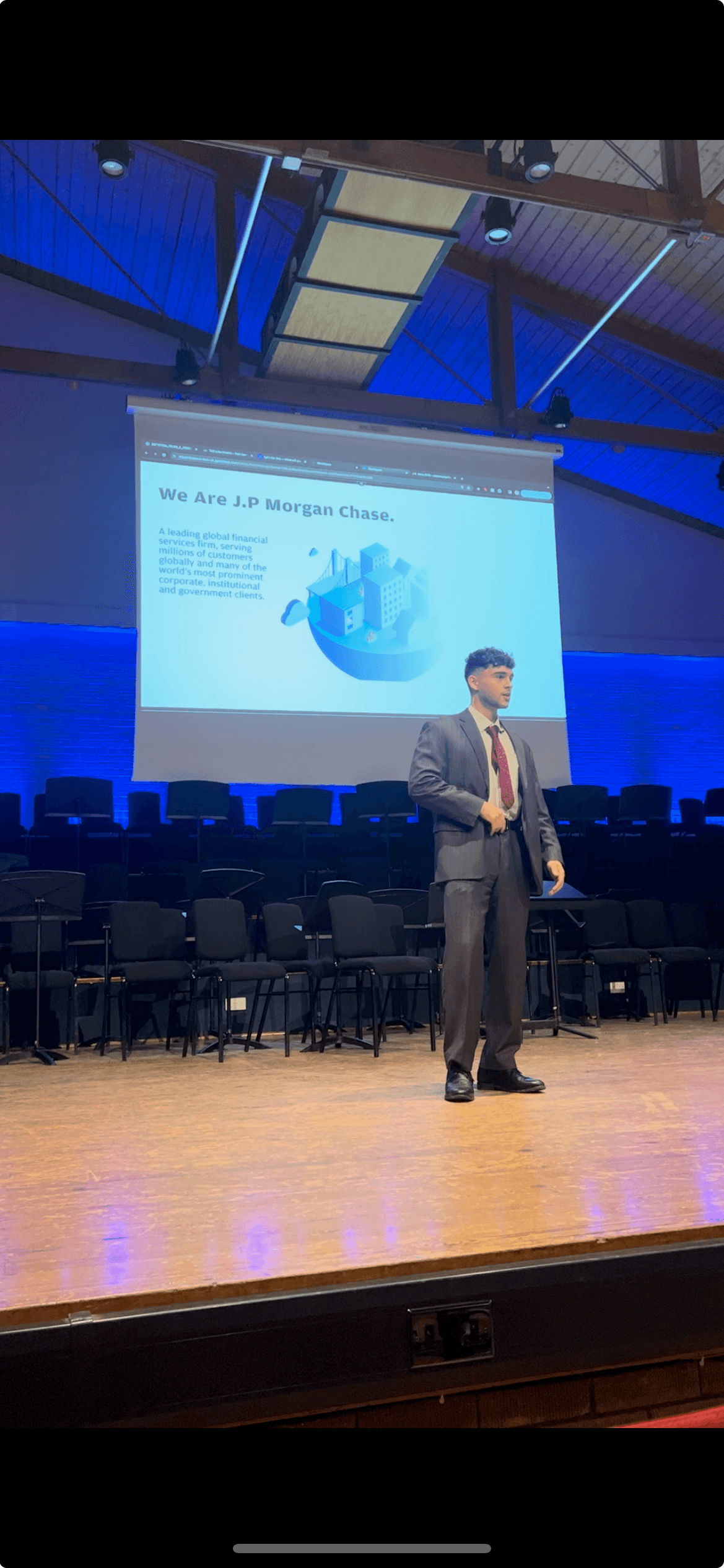 Arun speaking on stage at a J.P. Morgan event